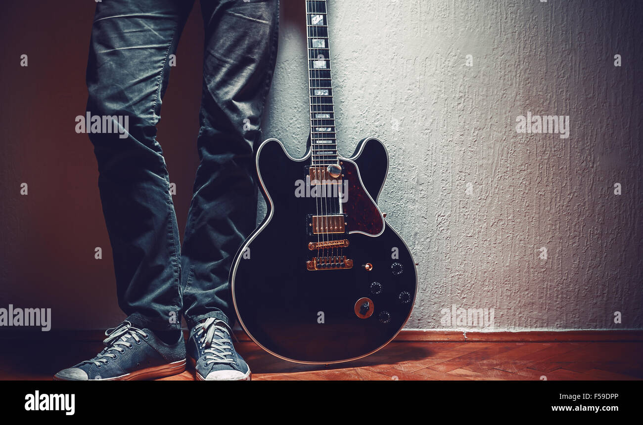 Black electric guitar, 335 model and a part of its owner. Stock Photo