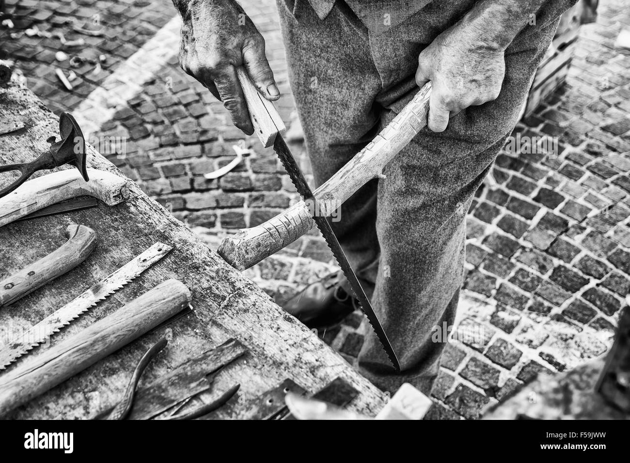Old craftsman builds Hacksaw using the steel of old scythes. Stock Photo