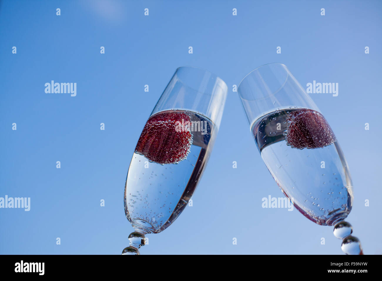 Glasses of champagne and strawberries with a background of blue sky. Stock Photo