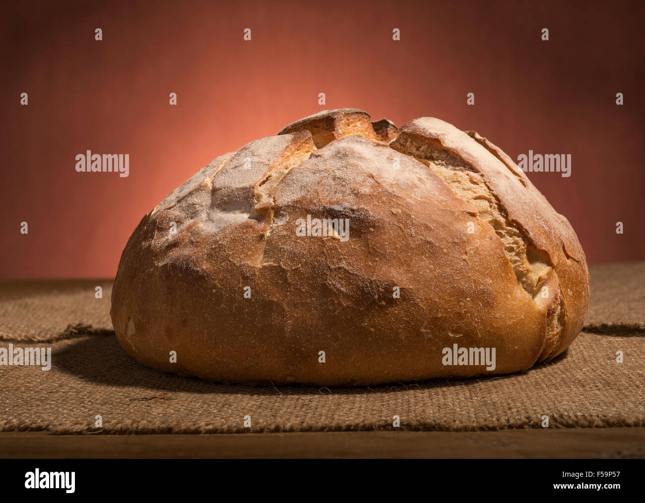 https://c8.alamy.com/comp/F59P57/loaf-of-fresh-homemade-sour-dough-bread-on-wooden-table-F59P57.jpg