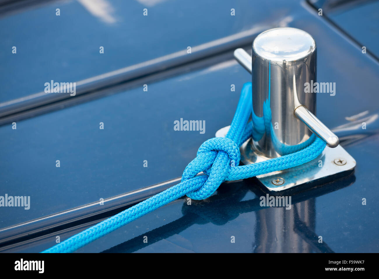 A mooring rope with a knotted end tied around a cleat Stock Photo