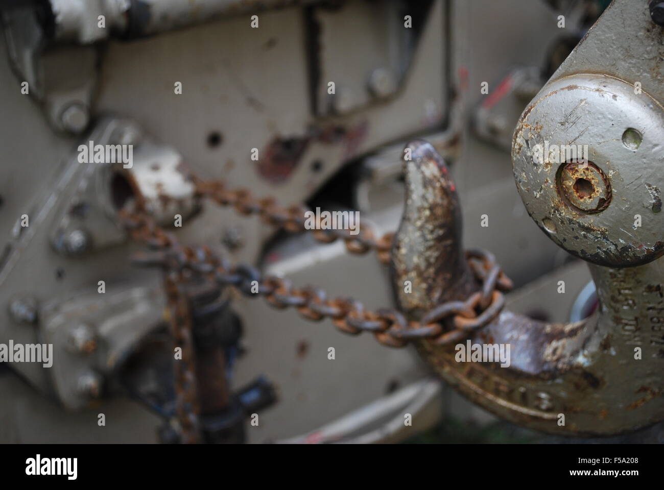 Rusted hook attached to machinery by a metal chain Stock Photo