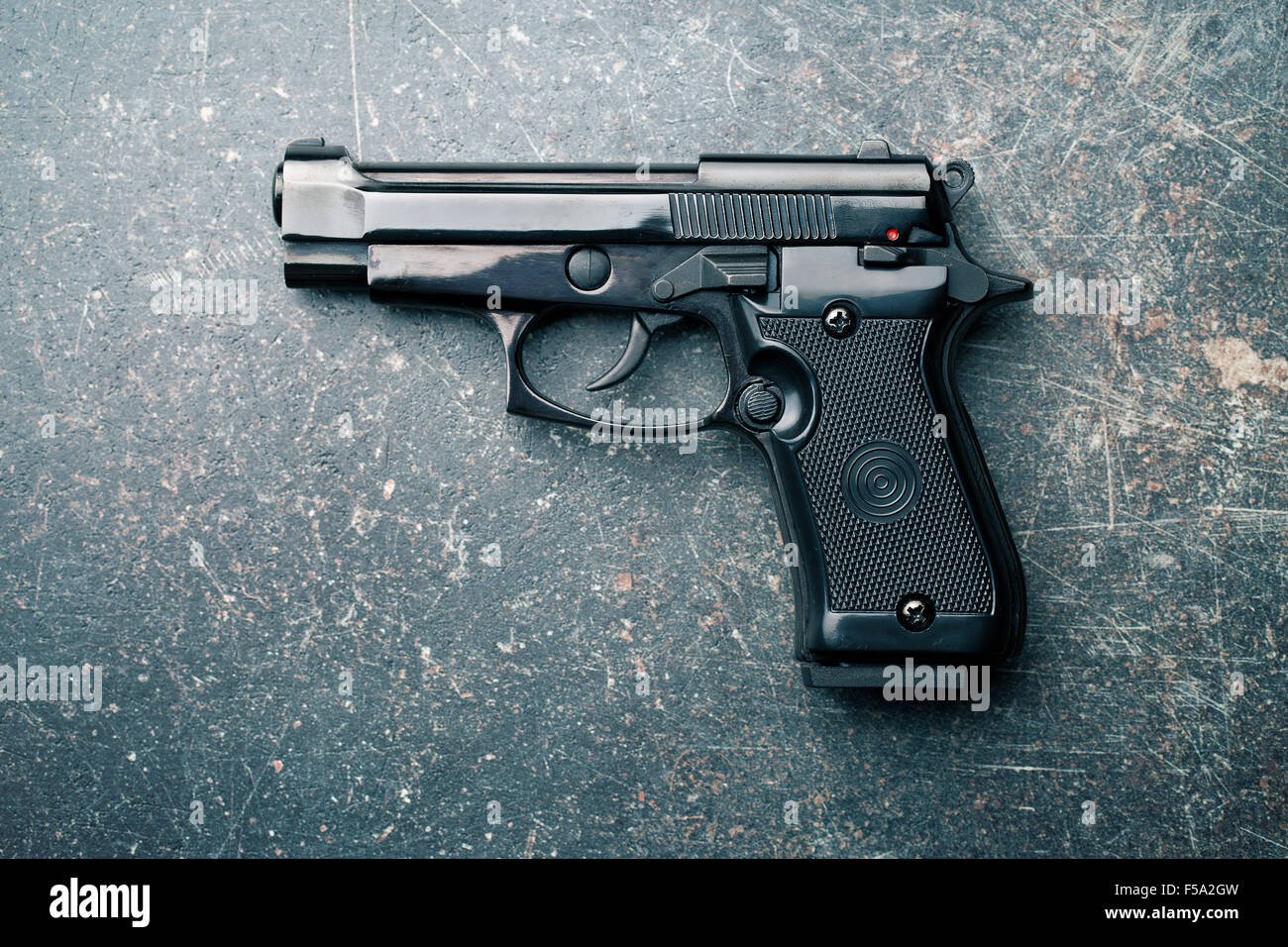 black handgun on old crackle background Stock Photo