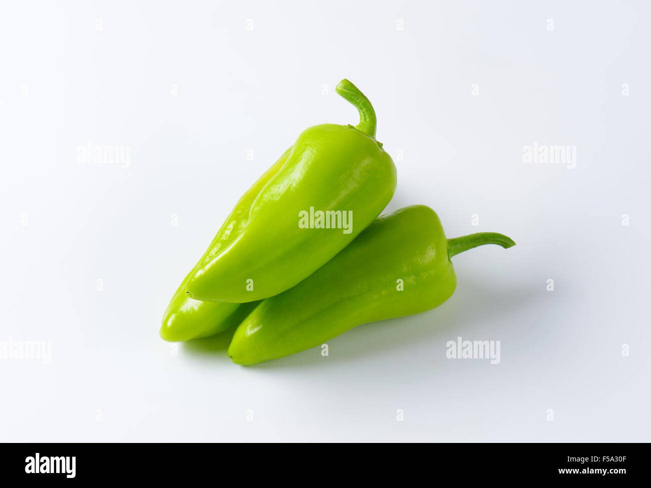 Three green peppers on white background Stock Photo