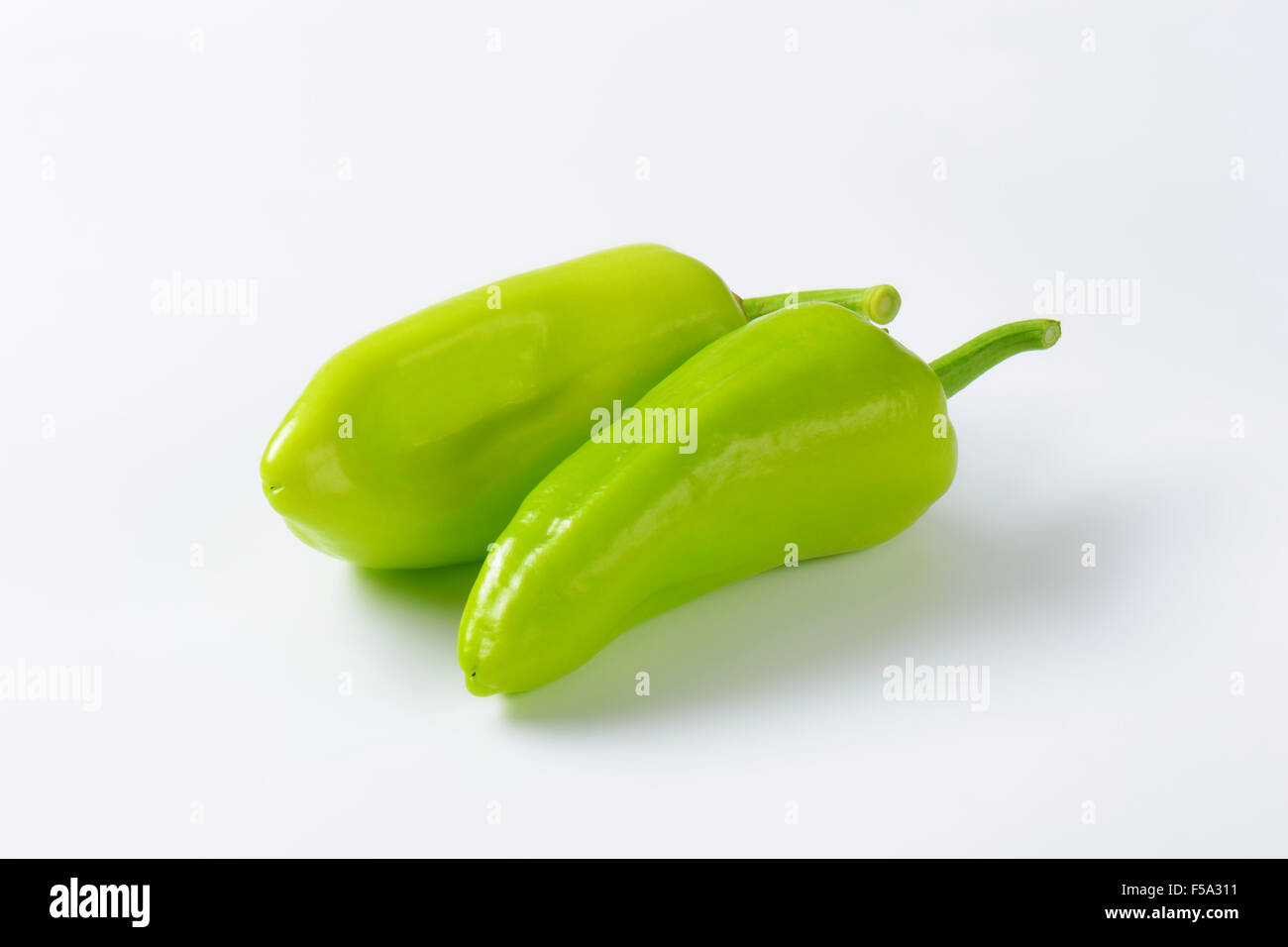 Two green peppers on white background Stock Photo