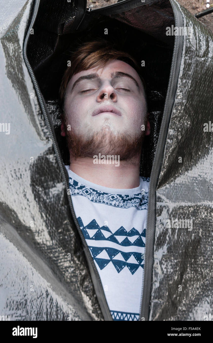 The body of a young man inside a body bag about to be zipped up. Stock Photo