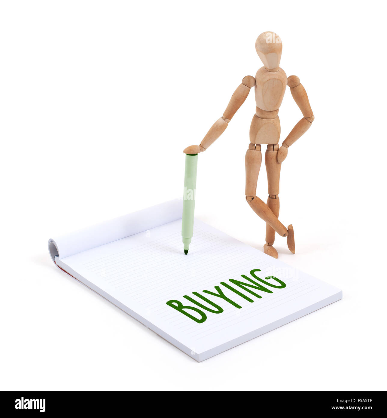 Wooden mannequin writing in a scrapbook - Buying Stock Photo