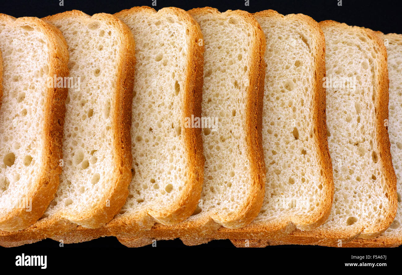 White bread slices in a row on black background Stock Photo - Alamy