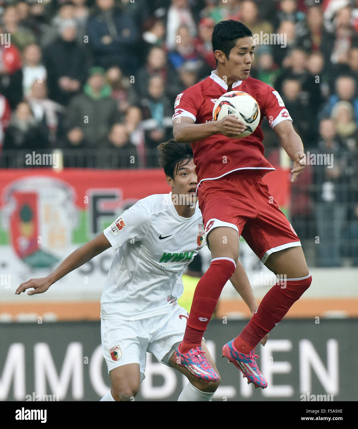 Augsburg, Germany. 31st Oct, 2015. Mainz's Yoshinori Muto (R) and Augsburg's Augsburgs Jeong- Ho Hong vie for the ball during the German Bundesliga soccer match between FC Augsburg and FSV Mainz 05 in Augsburg, Germany, 31 October 2015. Photo: STEFAN PUCHNER/dpa (EMBARGO CONDITIONS - ATTENTION - Due to the accreditation guidelines, the DFL only permits the publication and utilisation of up to 15 pictures per match on the internet and in online media during the match)/dpa/Alamy Live News Stock Photo