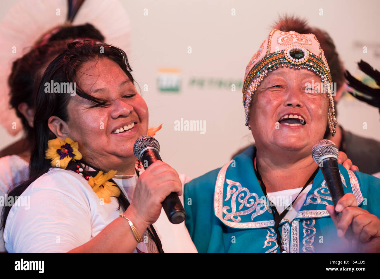 Palmas, Tocantins State, Brazil. 29th October, 2015. Alexandra Grigorieva, the single delegate from Siberia, sings with a Terena woman during a cultural event at the International Indigenous Games, in the city of Palmas, Tocantins State, Brazil. Credit:  Sue Cunningham Photographic/Alamy Live News Stock Photo