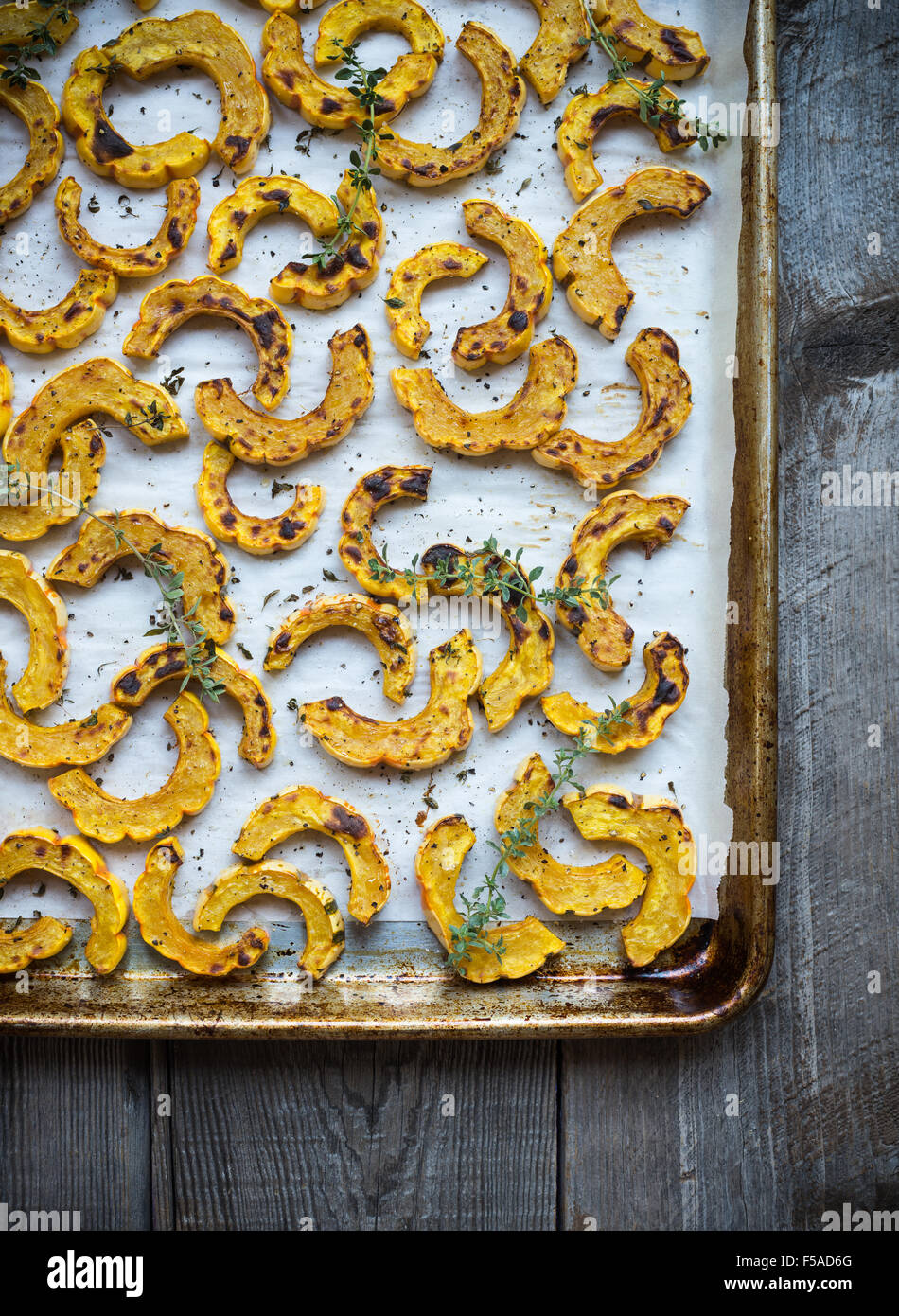 Sheet pan with freshly roasted delicata squash on parchment Stock Photo