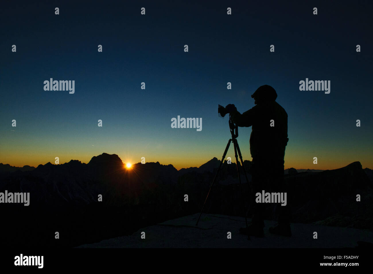 Photographer taking photos at sunset from the Nuvolau, above Passo Falzarego, Belluno, Italy Stock Photo
