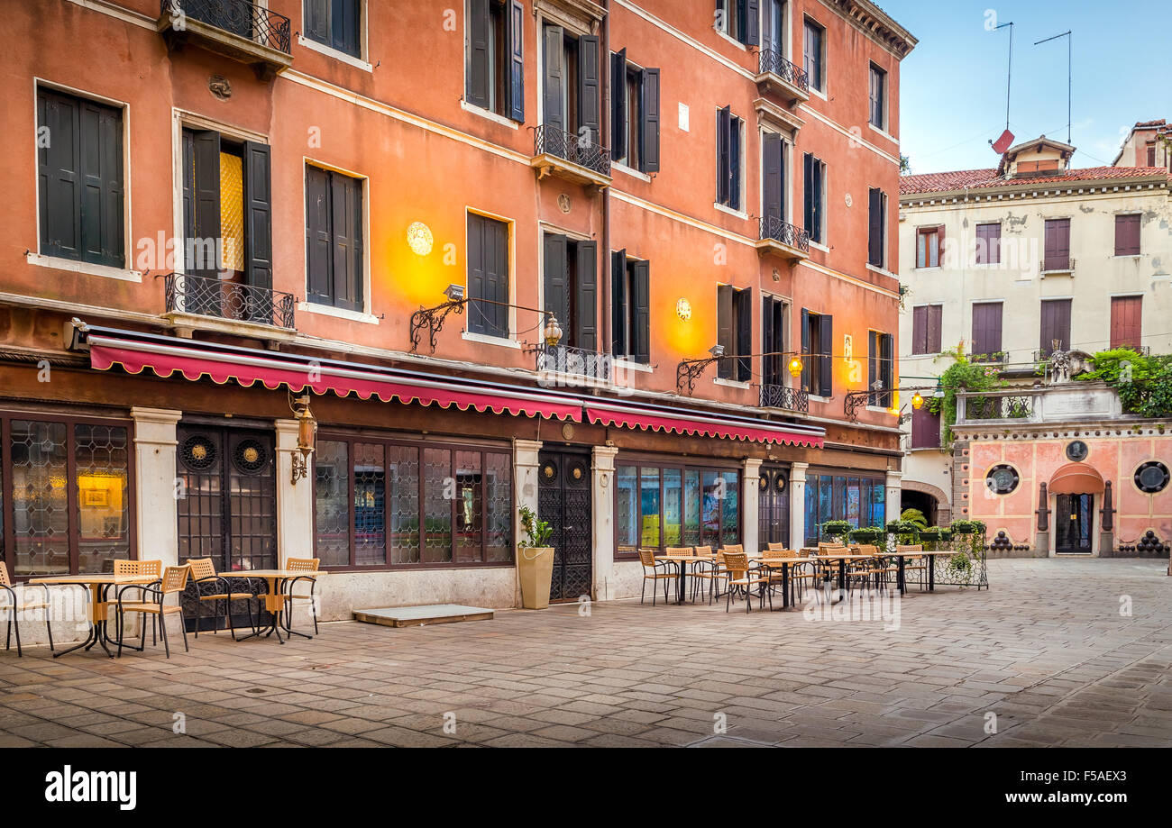 Chairs and tables in front of venetian cafe Stock Photo