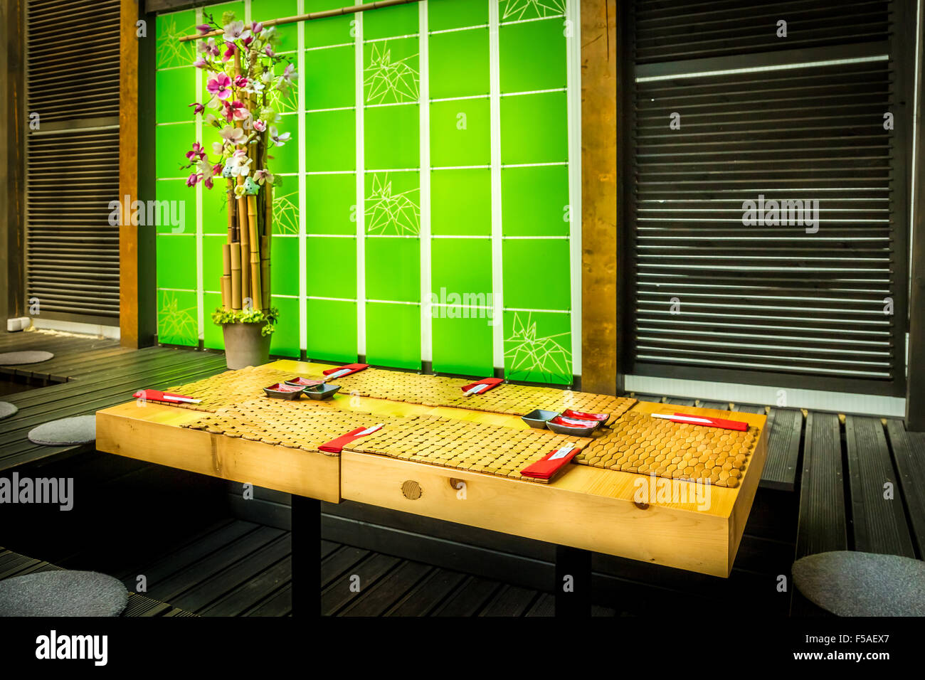 Cosy sushi restaurant with wooden table and green decorative wall Stock Photo
