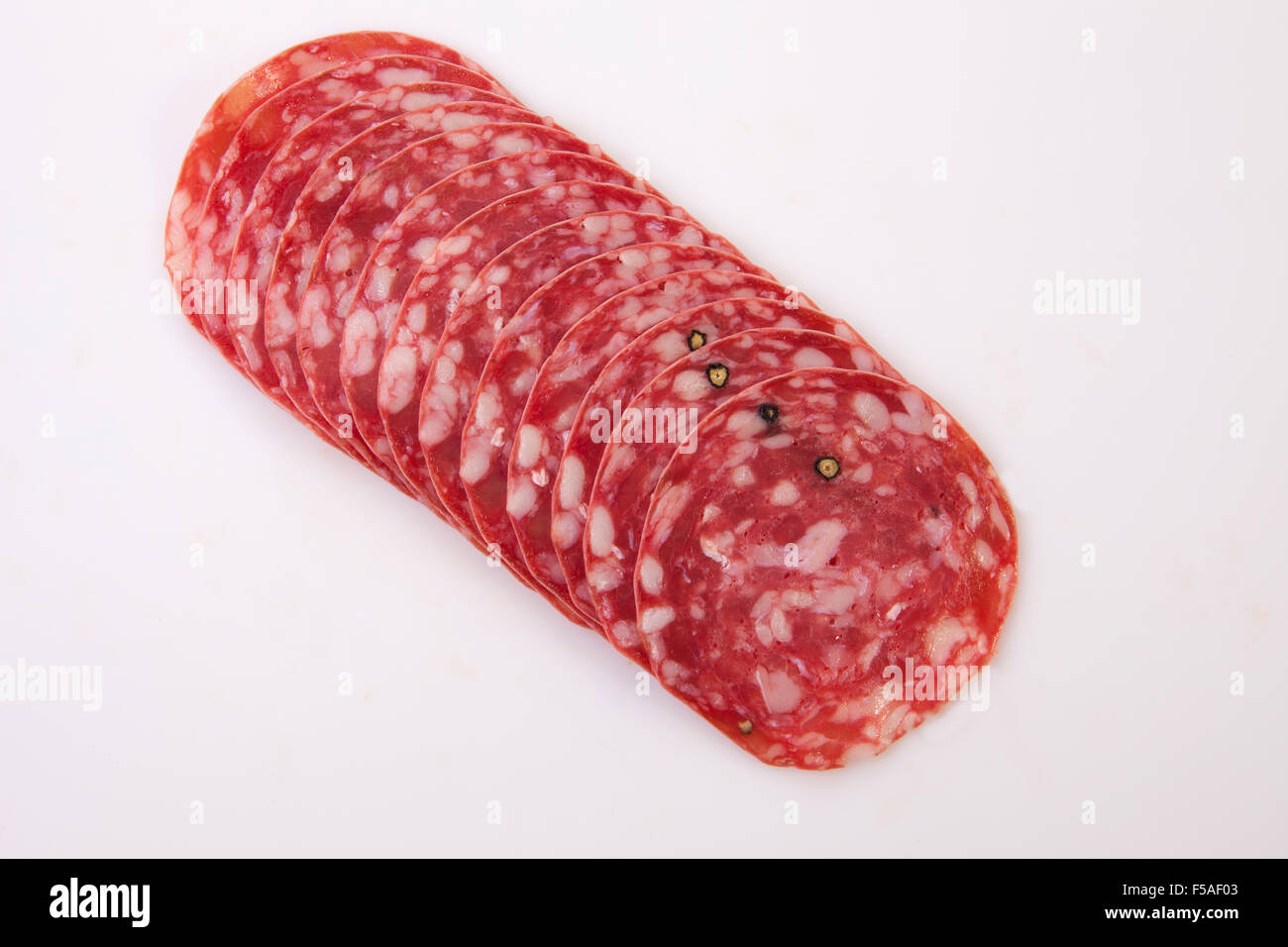 Closeup of sliced summer sausage. Isolated over white background Stock
