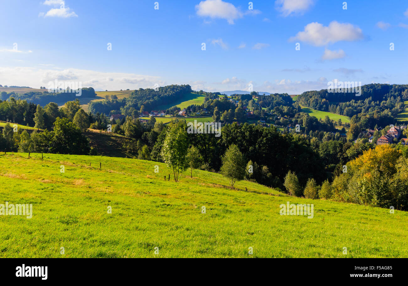 Beautiful sunset over countryside landscape of rolling hills with sun beams piercing sky and lighting hillside Stock Photo