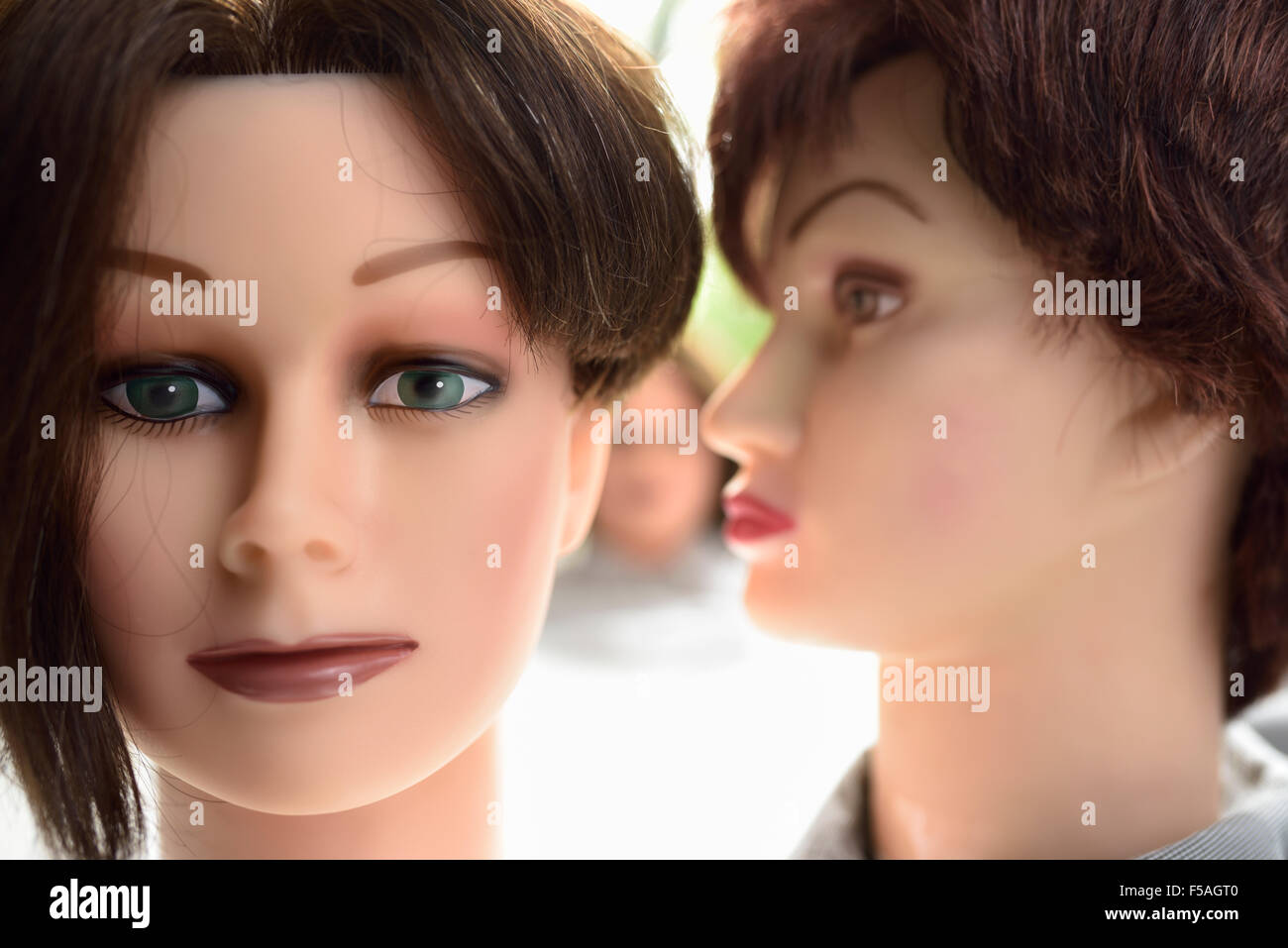 Female mannequin heads showing whispering a secret Stock Photo
