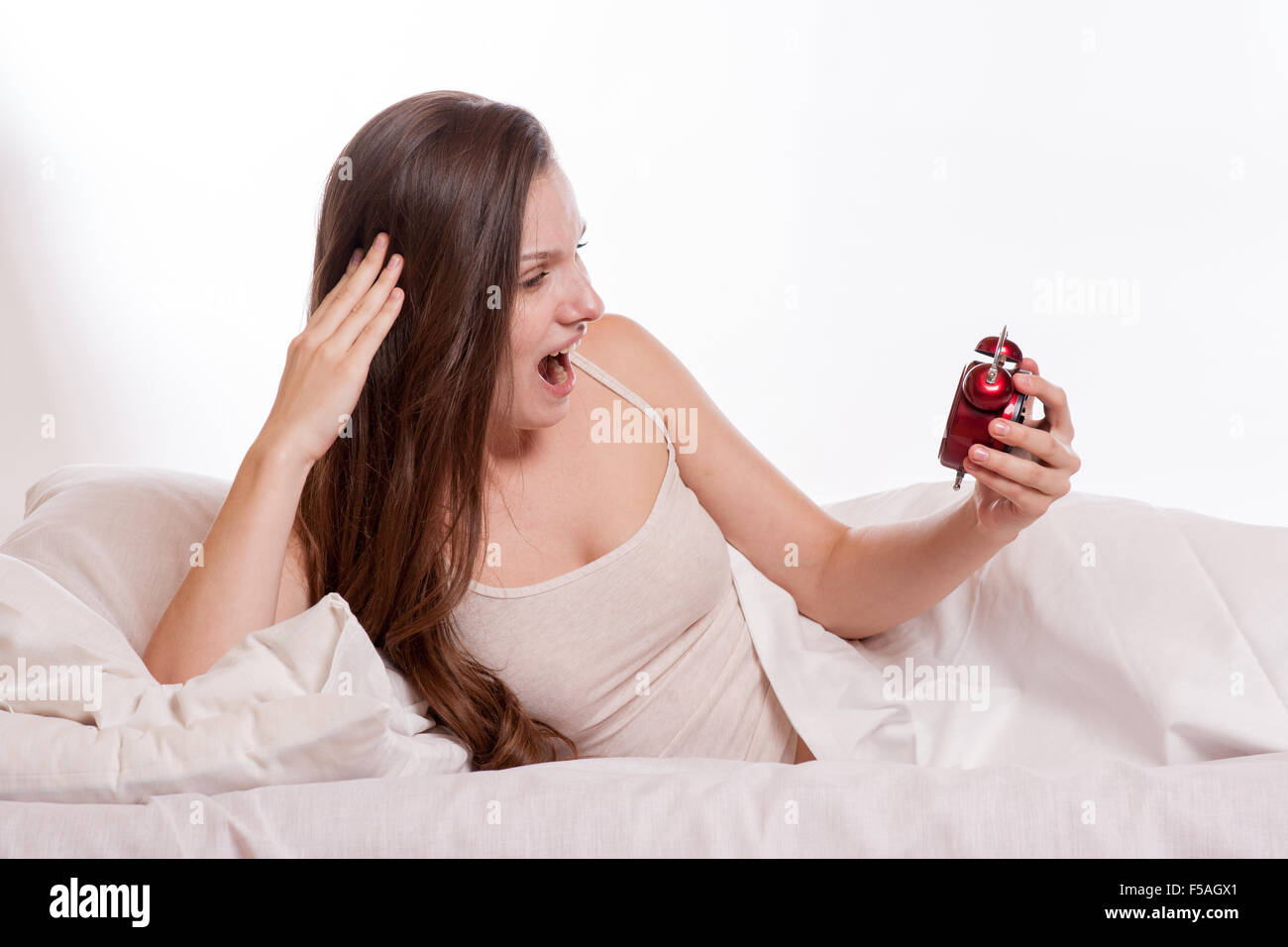 Portrait Of Young Woman Screaming To The Alarm Clock. Stock Photo