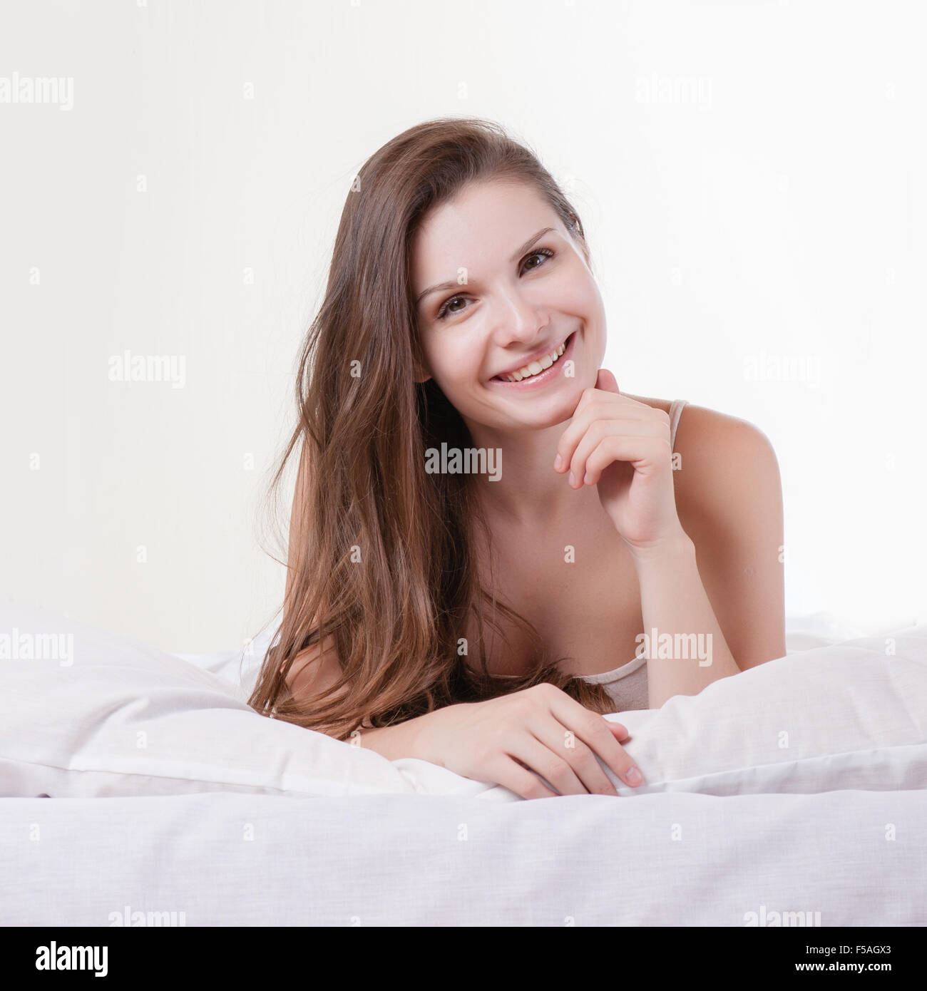 Beautiful romantic woman / girl brunette lying on the bed in her room at home. Stock Photo