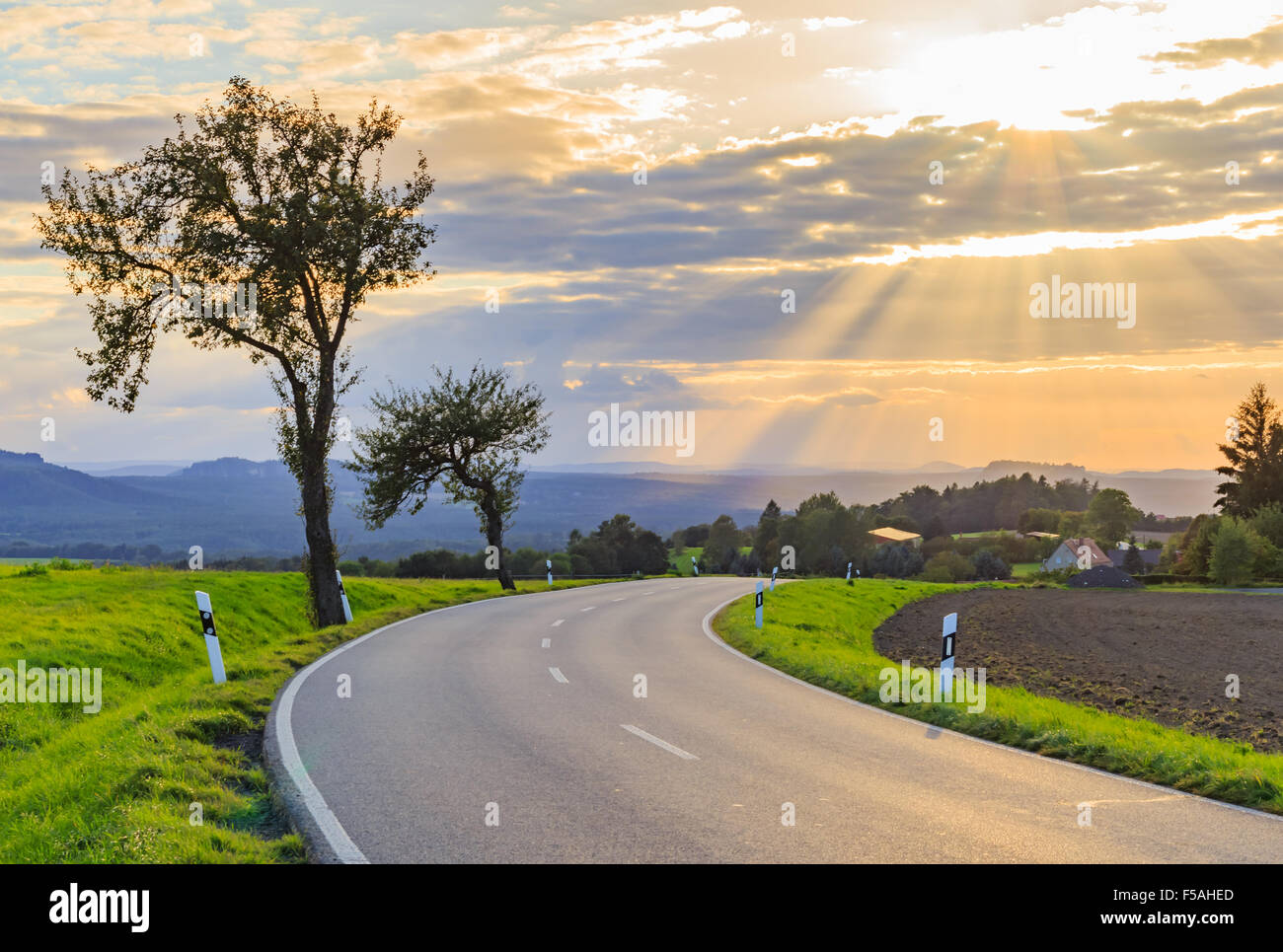 Panoramic landscape of colorful yellow-green hills with ground road, blue sky and clouds Stock Photo