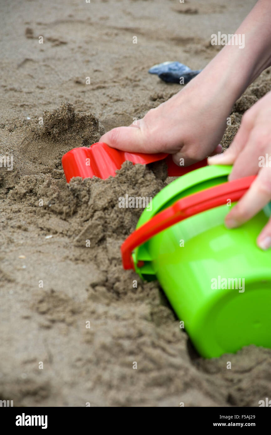 Toddler playing in sand with bucket and spade at beach Stock Photo Alamy