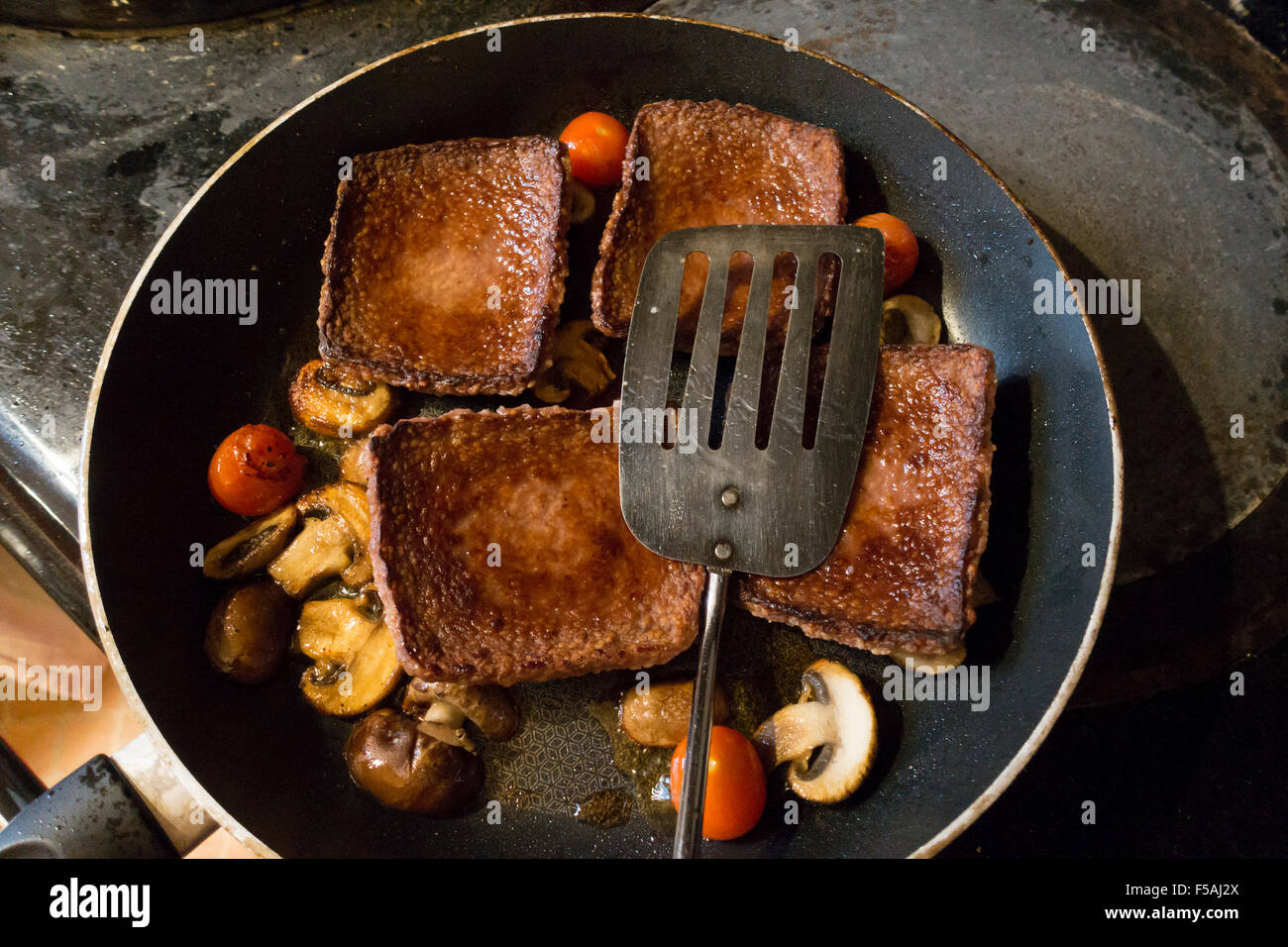Scottish flat square sausage beef or steak Lorne frying with mushrooms and tomatoes Stock
