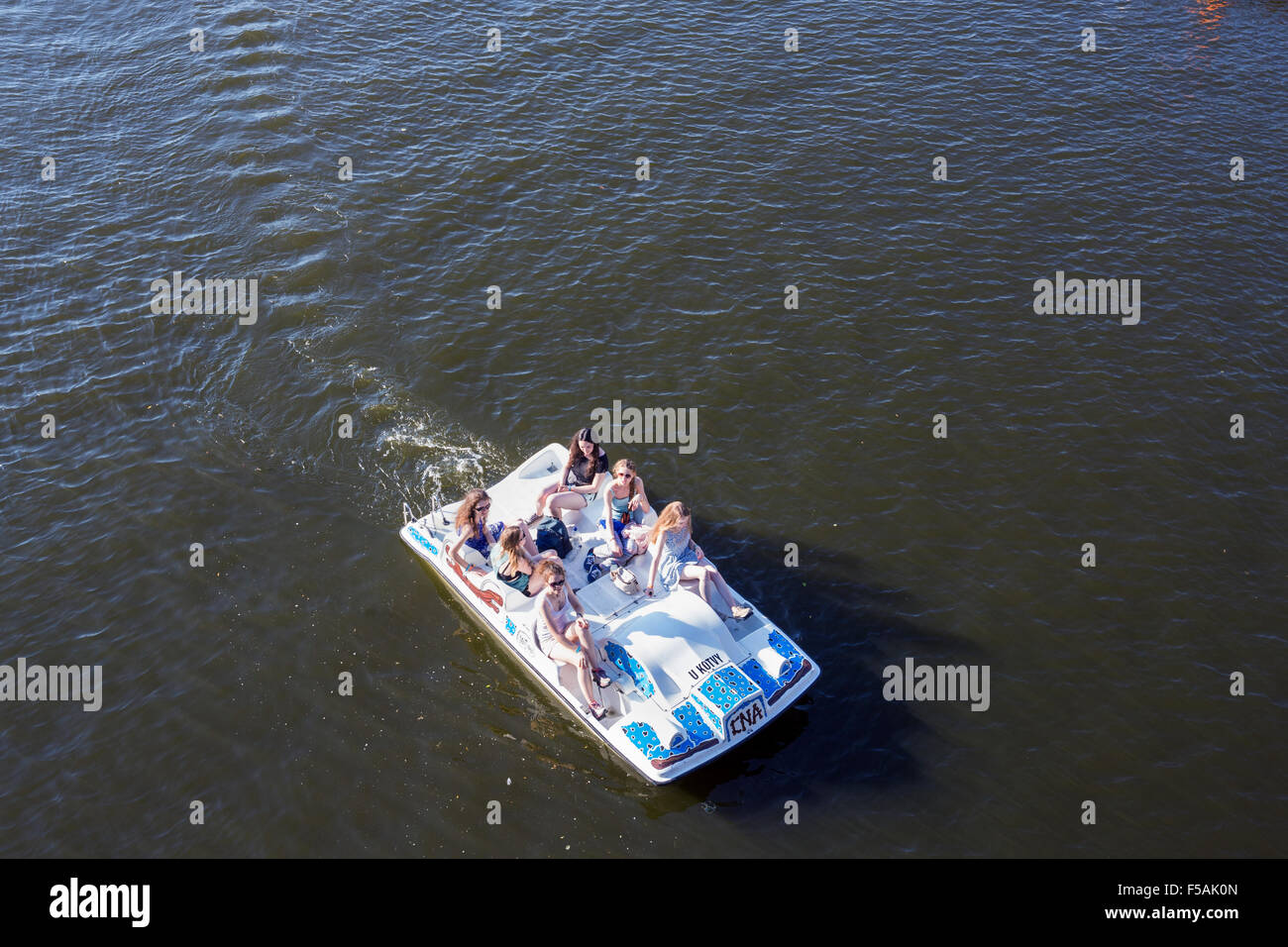 People riding a pedal boat on the Vltava river in Prague, Czech