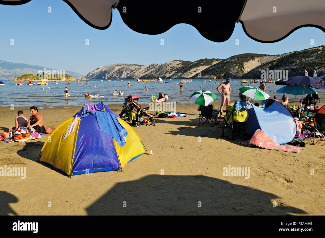 Under an umbrella at Paradise beach in Lopar, Rab island, Primorje-Gorski Kotar, Croatia Stock Photo