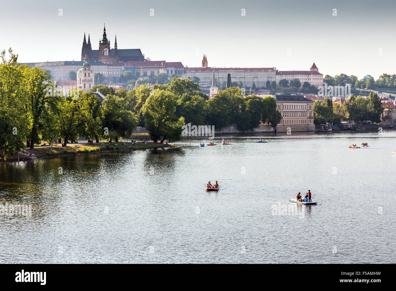 People in paddle boats in Vltava River, Prague castle and Strelecky