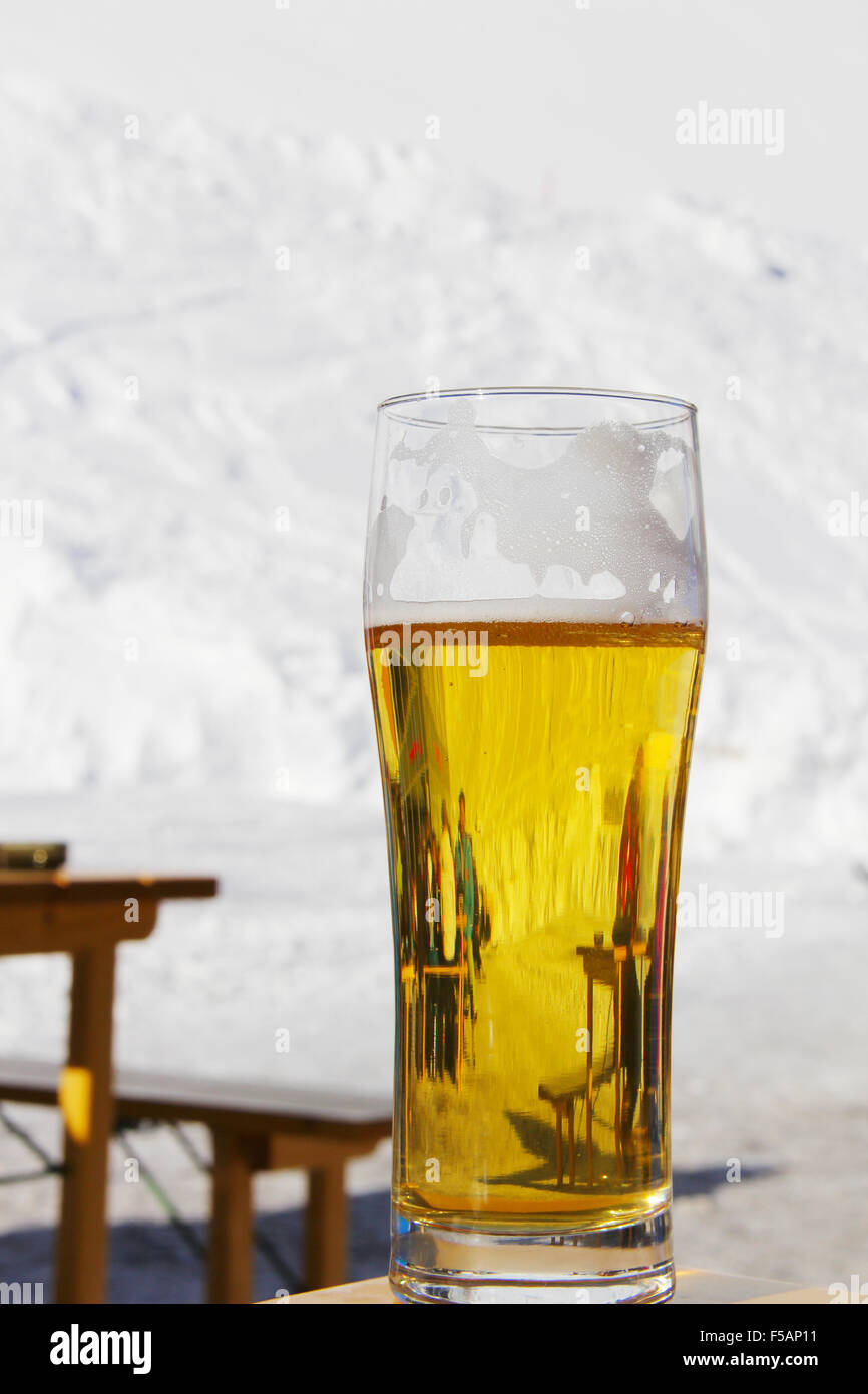 Glass with beer on a wooden table in high mountain cafe Stock Photo