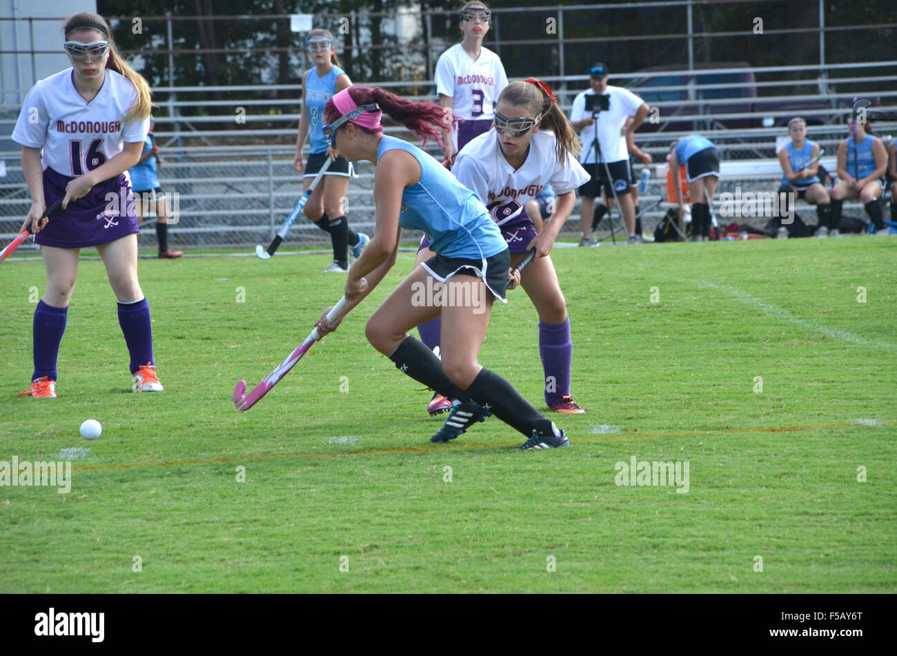 Girls playing field hockey in a high school game Stock Photo