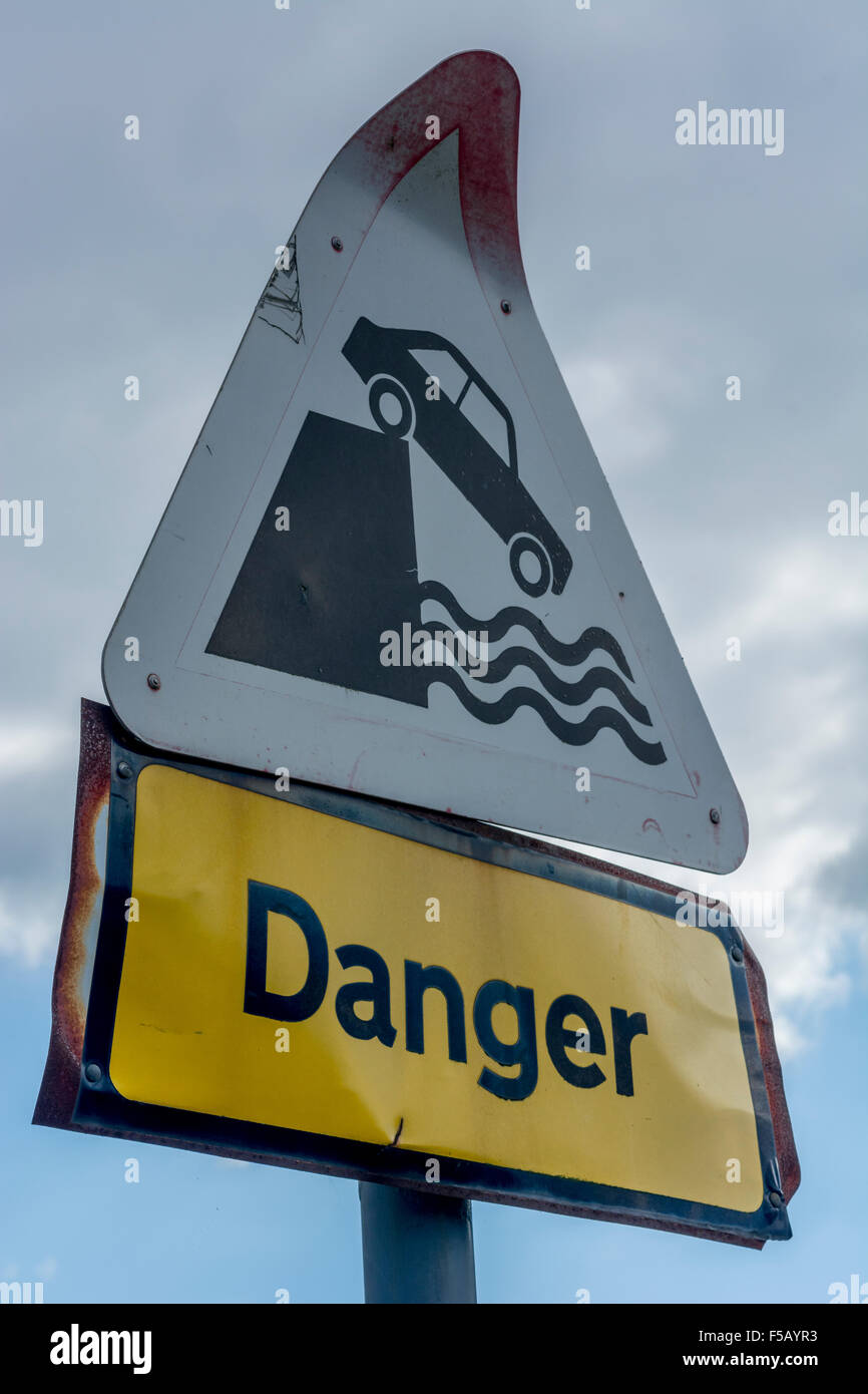 Warning sign by parking area next to river. Metaphor for dangers of hard Brexit, falling off concept, safety evaluation, Oops. Roadsigns UK. Stock Photo