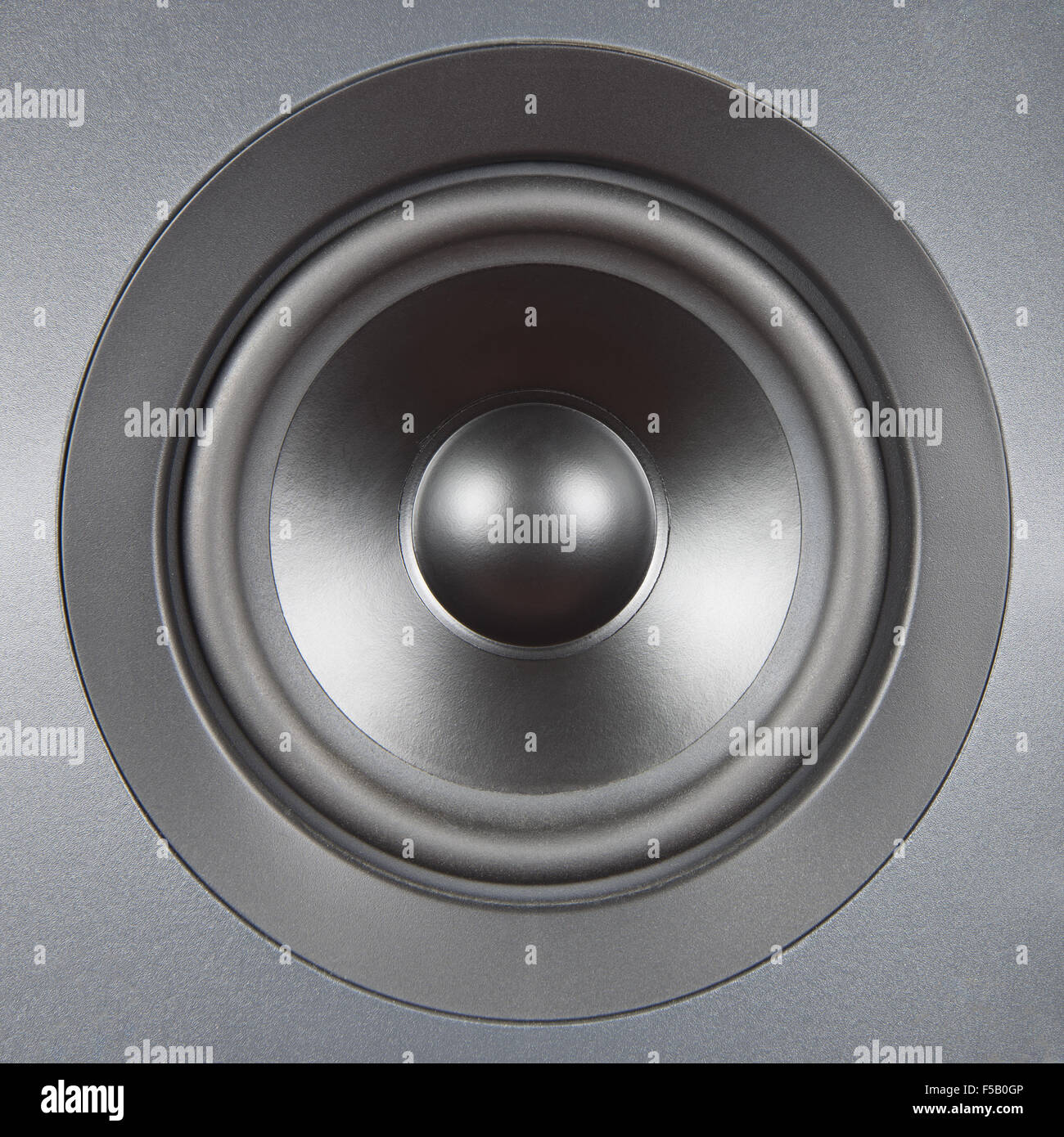 A silver speaker close up with symmetric light. Audio system equipment. Stock Photo