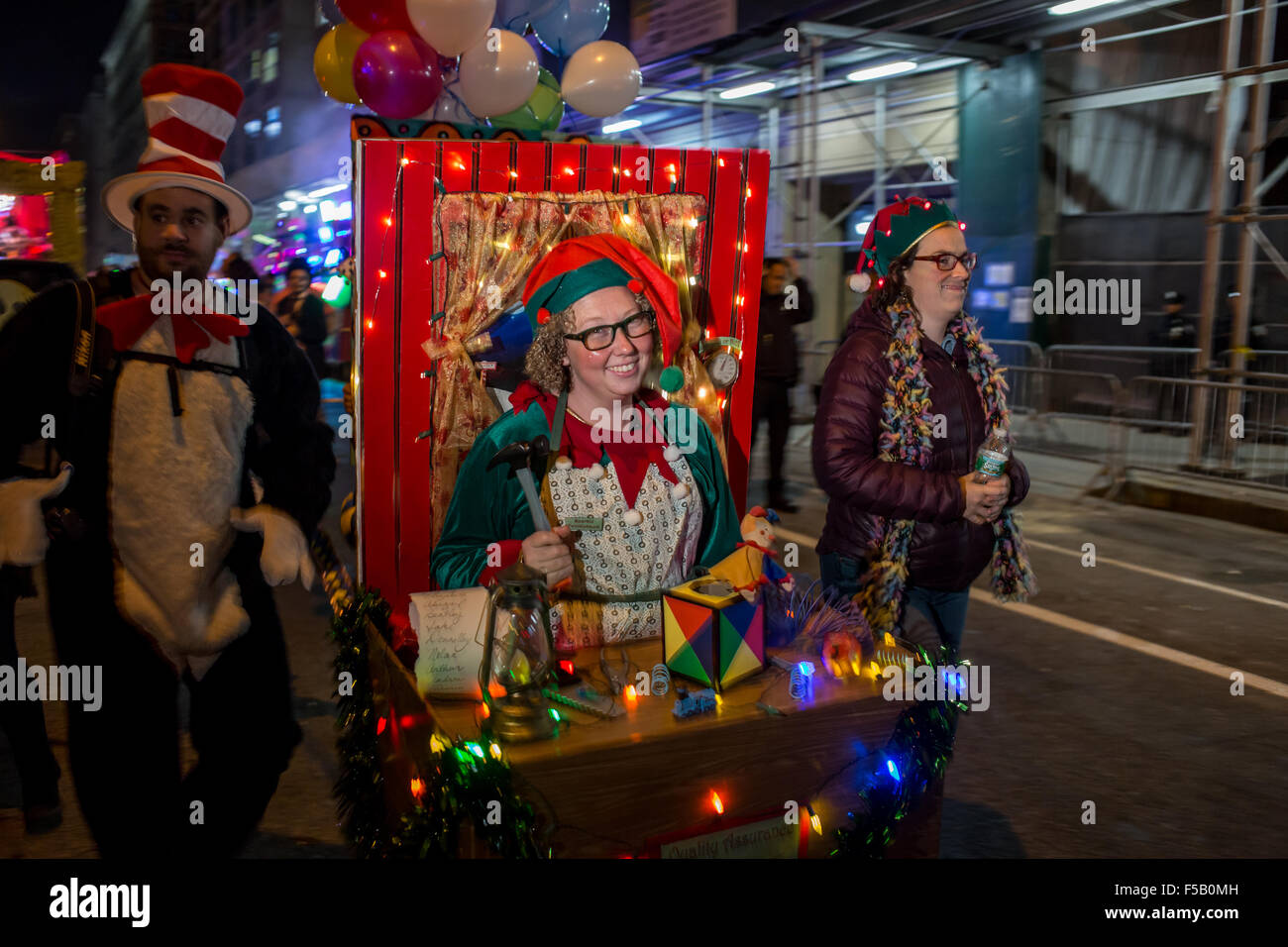New York, NY - 31 October 2015. A woman dressed as an elf in Santa's workshop, complete with workbench, tools and toys, at the start of the annual Greenwich Village Halloween Parade. Her name tag reads 'Sparkle Twinklebaum.' Stock Photo