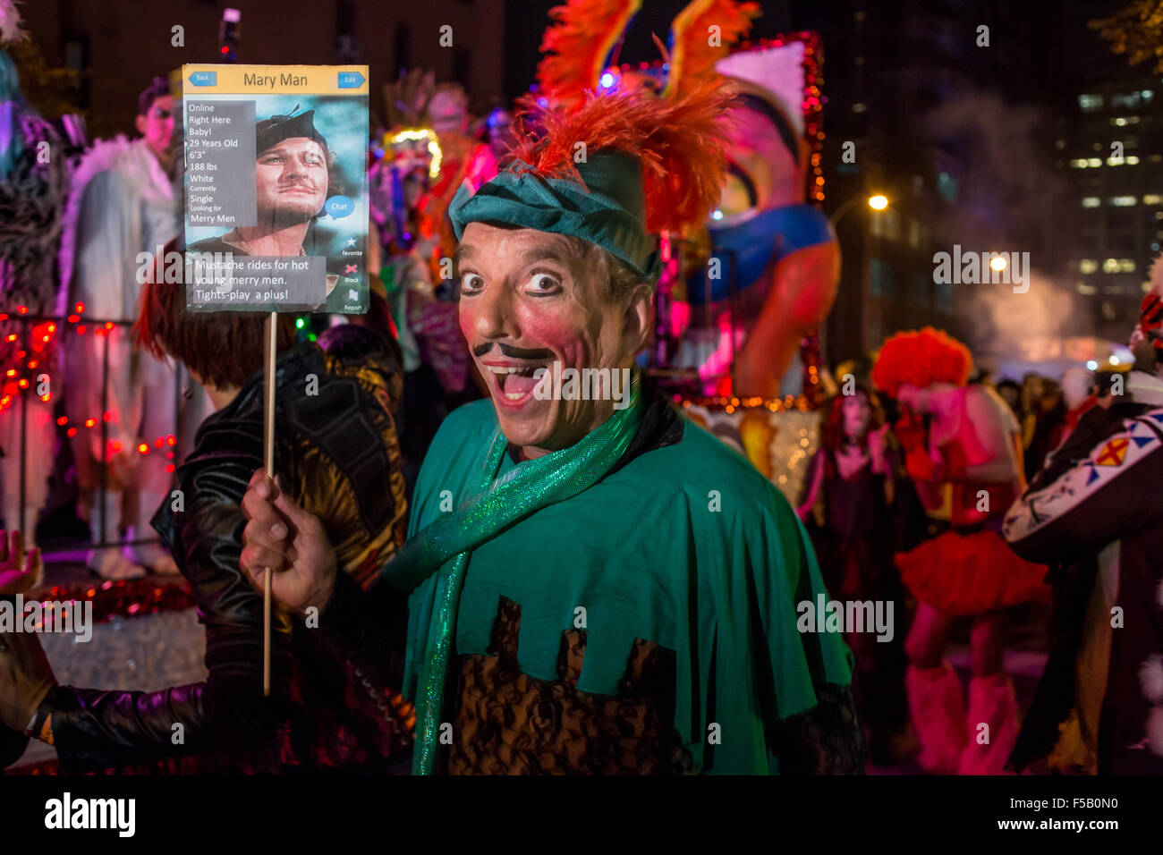 New York, NY - 31 October 2015. A man in heavy makeup, wearing a green Robin Hood costume, carries a sign that says 'Mary Man', and advertising that he's looking for merry men. Stock Photo