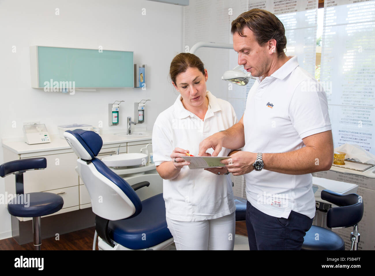 Dentist office, dentist and assistant in a meeting, checking a patient file, Stock Photo