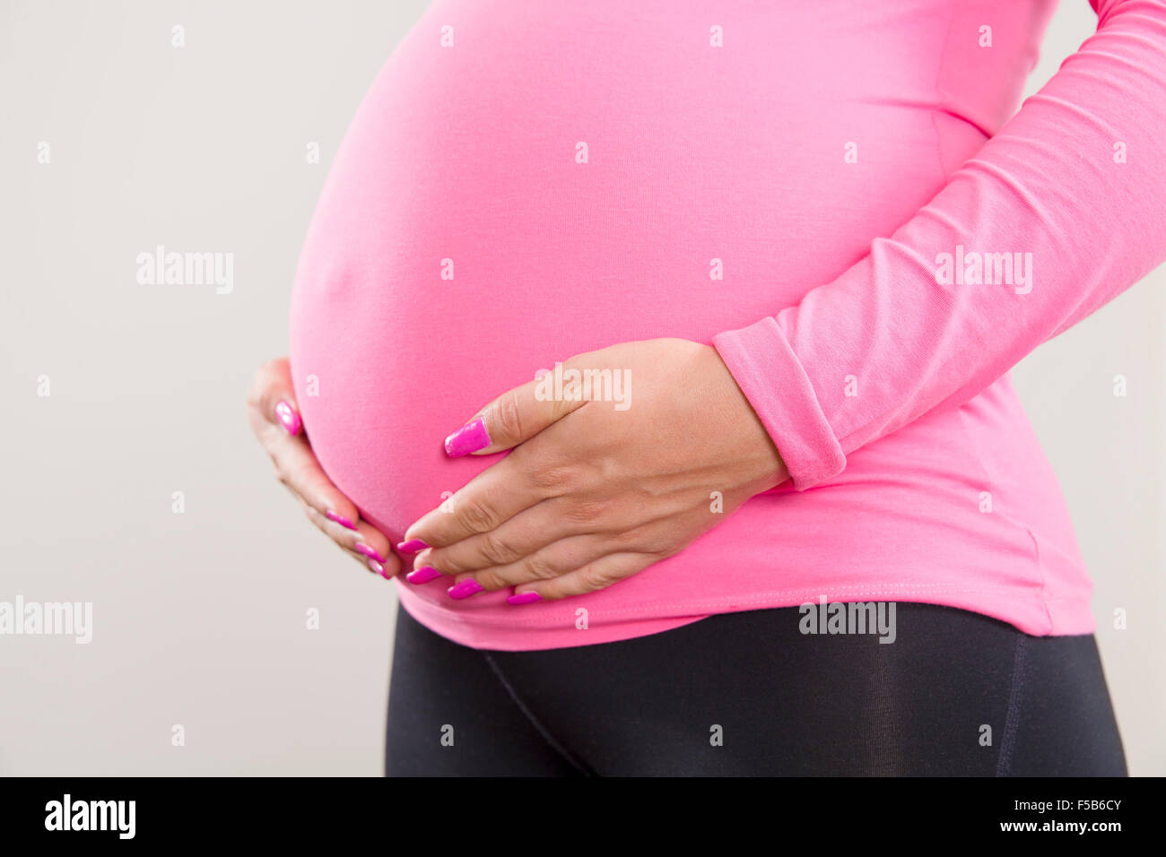 Pregnant woman holds on her swollen belly Stock Photo Alamy
