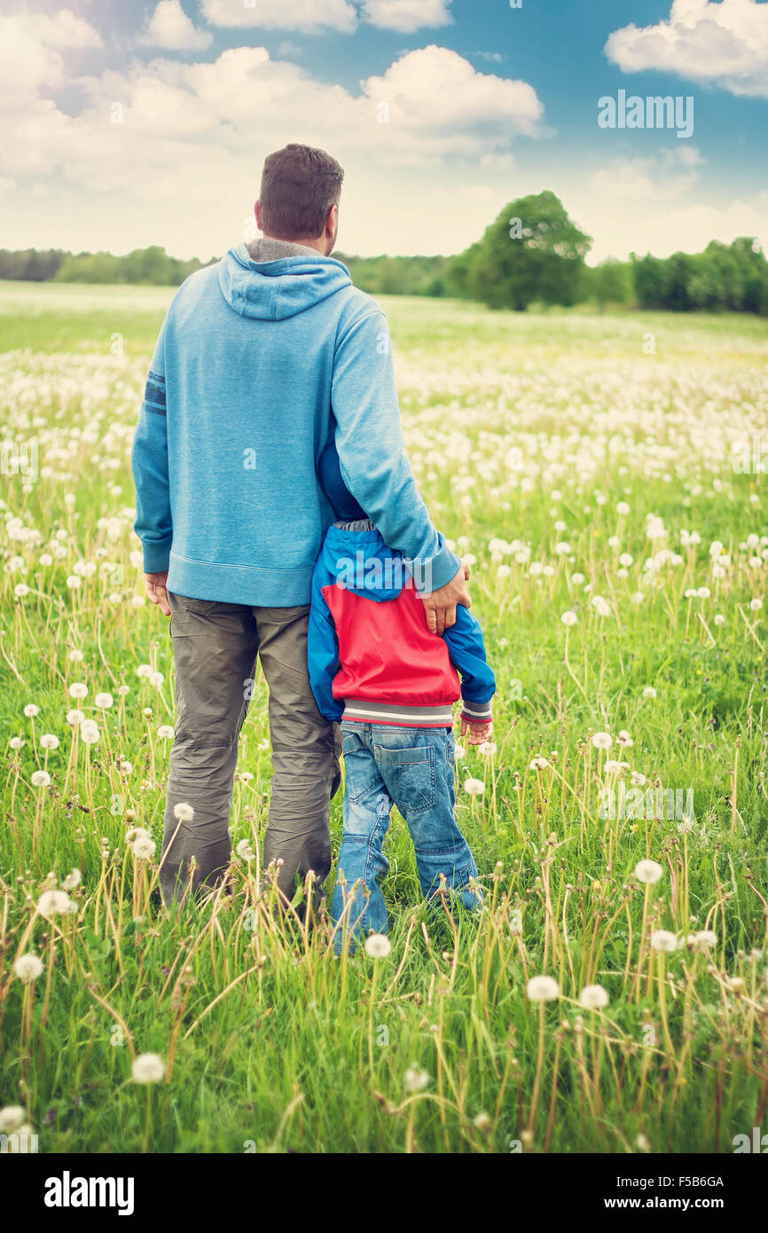 Father and son on dandelion field Stock Photo