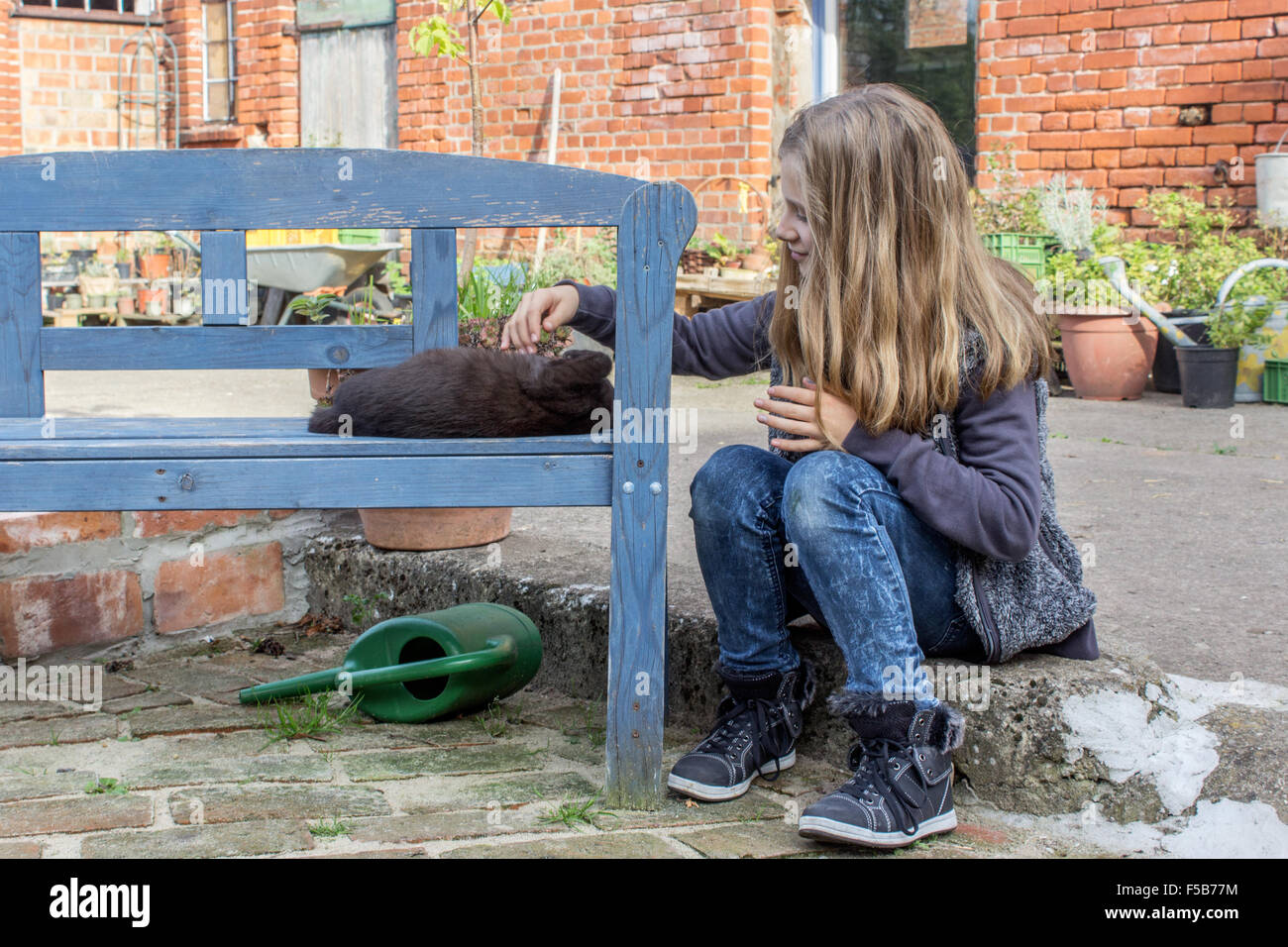 A girl stroking a black cat Stock Photo