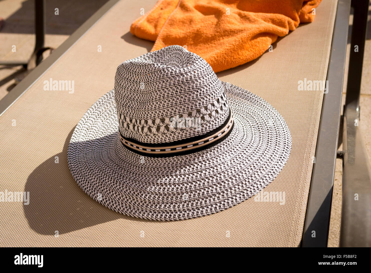 Sun Hat and Towel on Empty Sun Bed Stock Photo
