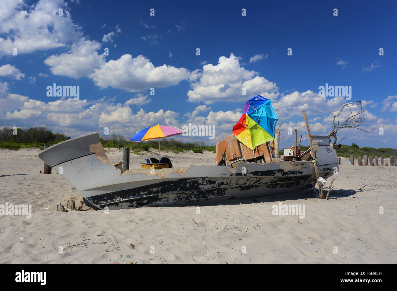 A derelict boat on a beach turned into a temporary bungalow Stock Photo