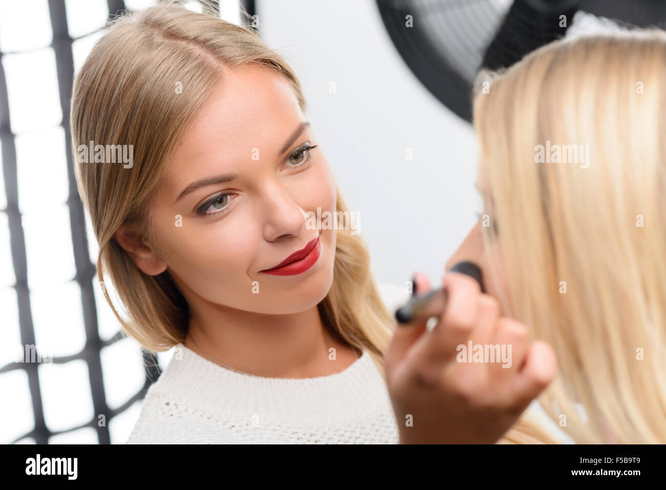 Professional makeup artist enjoys her work Stock Photo - Alamy