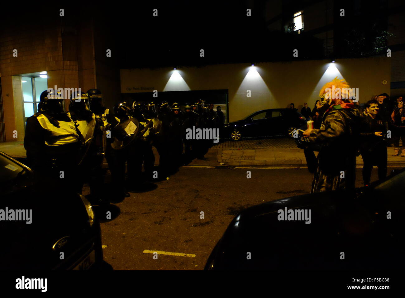 Riot police block road in Lambeth outside illegal Halloween rave Clown and Police face off Stock Photo
