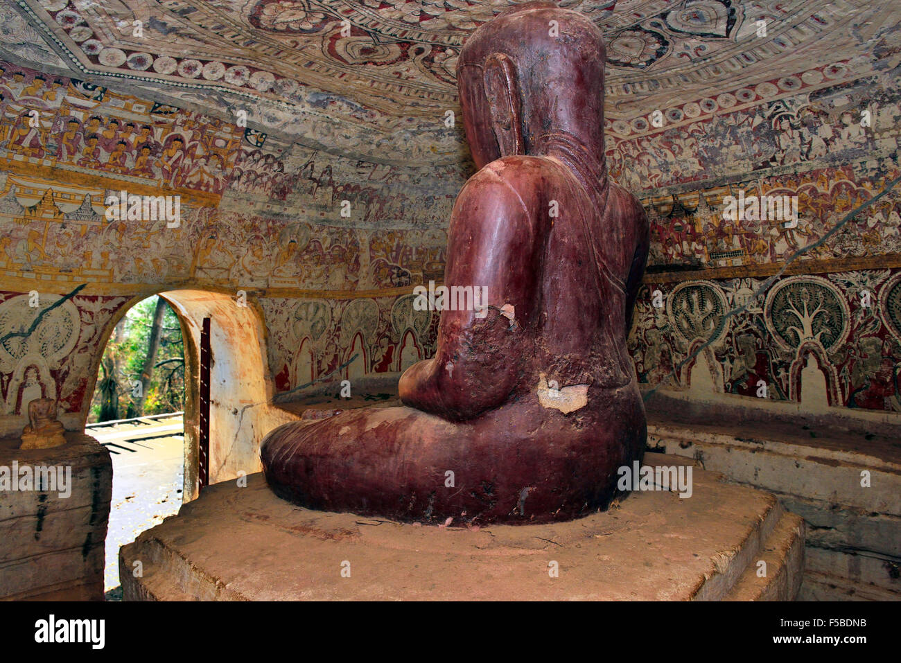 A carved Buddha statue inside one of Po Win Daung mountain caves carved into a sandstone outcrop and richly decorated Stock Photo