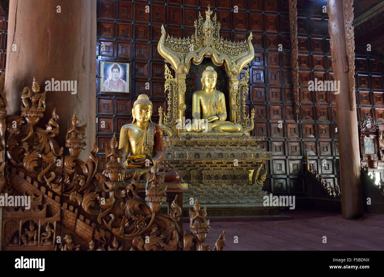 Interior with  central   golden buddha in  the historic teak wood temple of  Shwe in bin Kyaung in Mandalay, Myanmar, formerly Burma Stock Photo