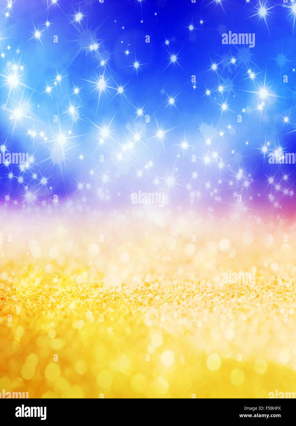 Abstract Christmas background with shiny stars in blue and gold color. New year lights, starry sky Stock Photo