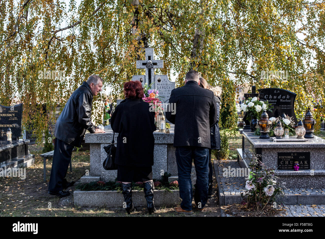 All Soul's Day in Poland on the 1st of November 2015. All Soul's Day is an important holyday in Poland. Many people gather in cemeteries to give respect to their loved ones who are already dead. Visitors light lights and bring flowers with them. Stock Photo
