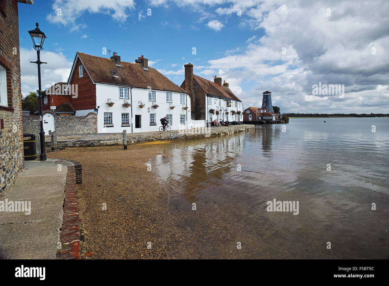 Langstone High Street, Hampshire at high tide showing the Royal Oak public house and Langstone Mill in the summer Stock Photo