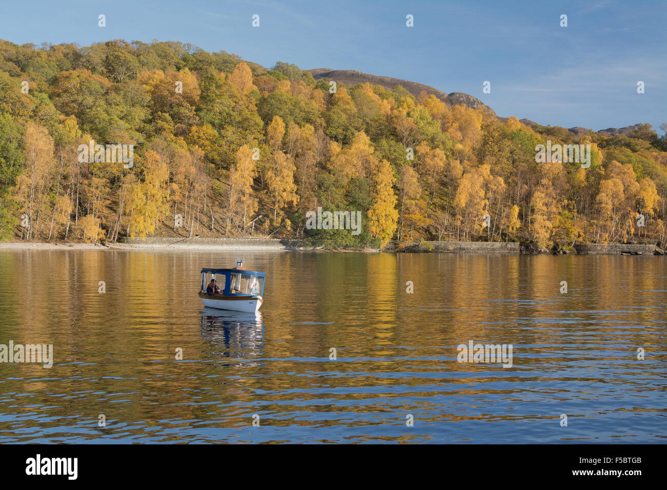 Loch Katrine, Scotland, UK - 1 November 2015: UK weather: enjoying a leisurely trip around Loch Katrine in a tiny steam boat on a beautiful autumn day Stock Photo