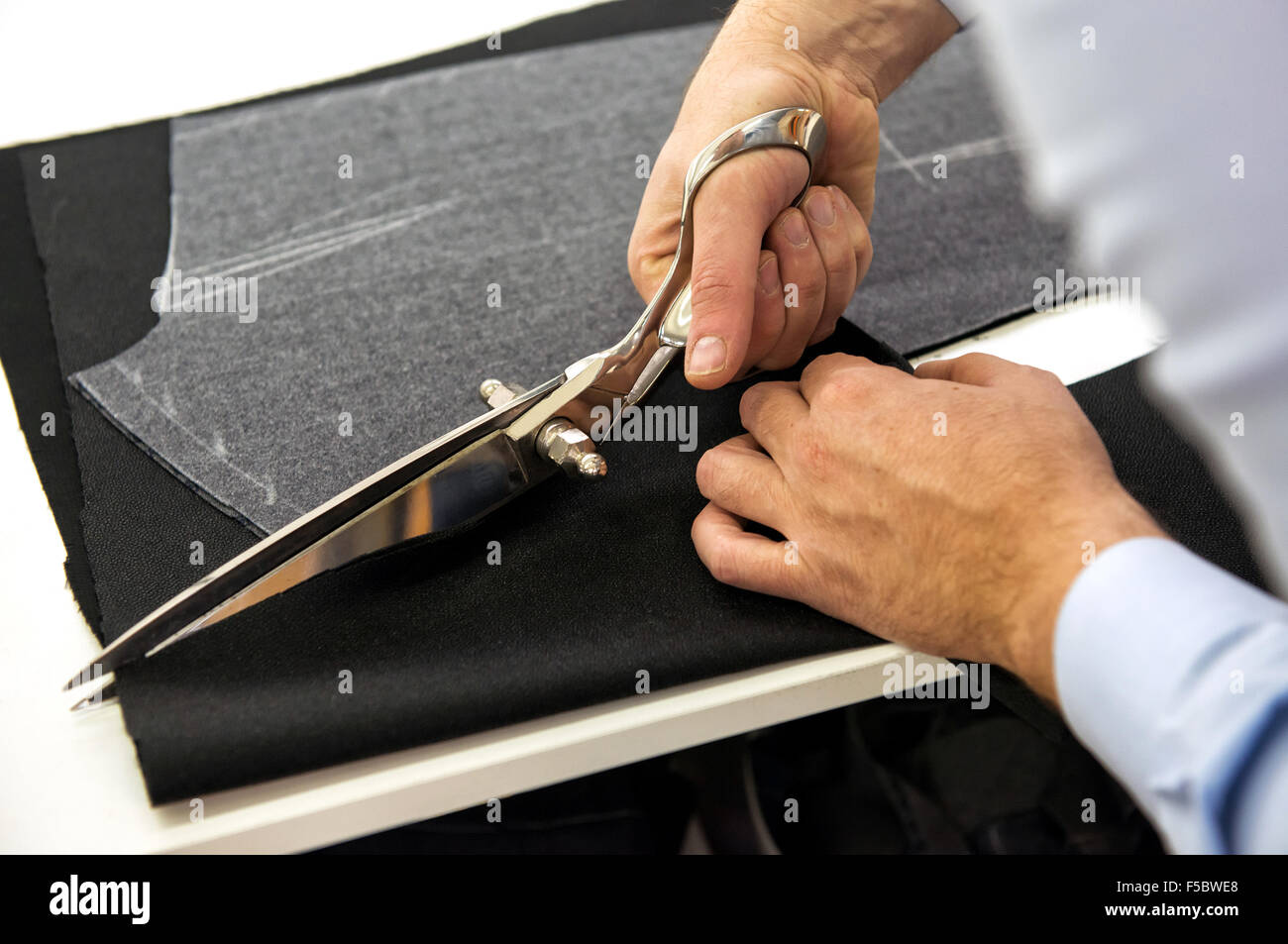 Tailor cutting fabric with shears Stock Photo